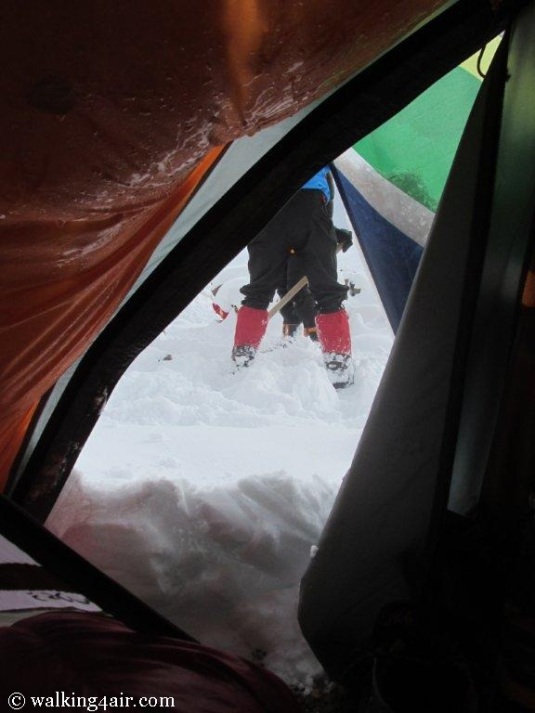 Snowed in at Camp 2! Other teams can be seen scrapping snow away from their tents. 